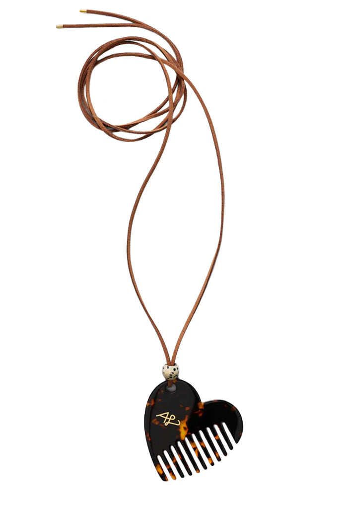 A heart-shaped tortoiseshell comb pendant necklace with a brown leather cord and a small gold-tone bead connector, shown on a plain white background.