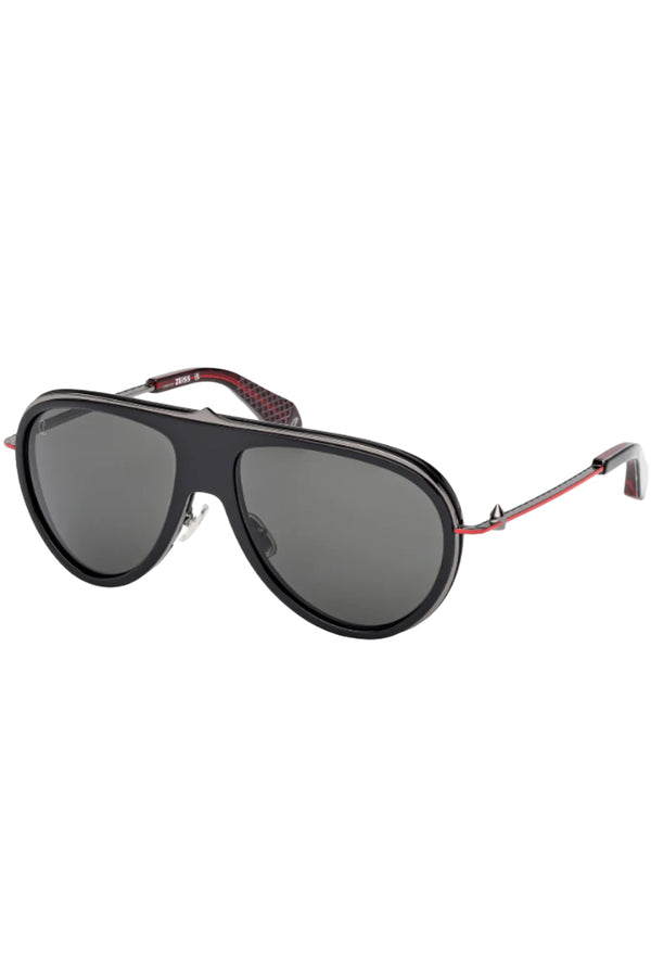 Rotated view of Christian Louboutin moto sunglasses in gray with black frame and spine in the middle, shown against a plaid white background.
