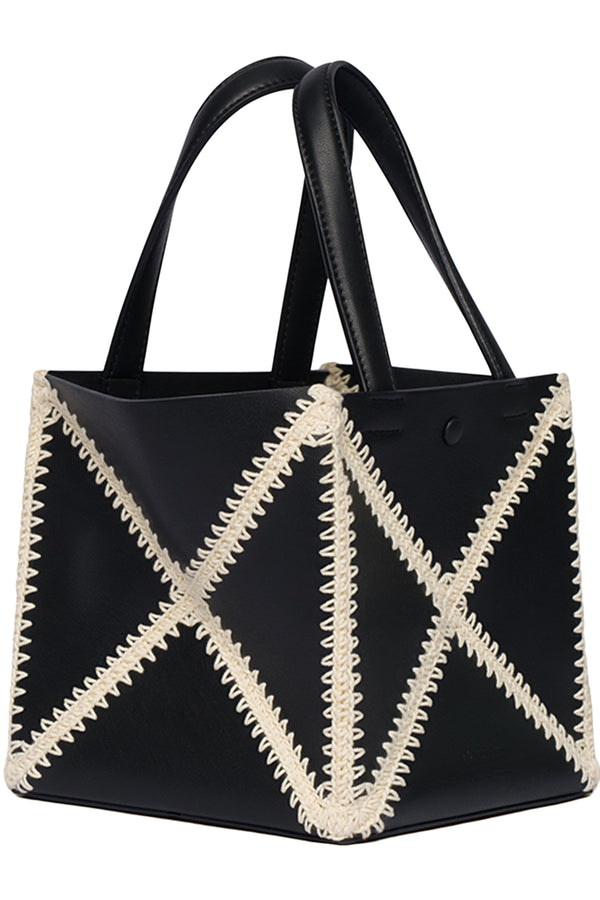 A black faux leather tote bag with cream-colored whipstitch geometric patterns on the front, featuring two black shoulder straps, photographed against a plain white background.