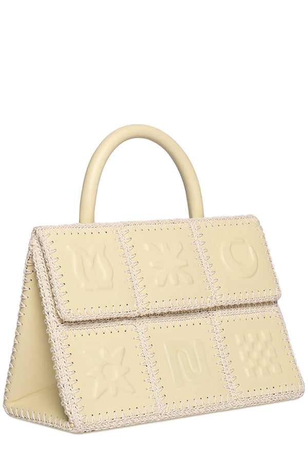 Rotated view of Nanushka handbag in beige from pieces with forms sewn together, shown against a plain white background.