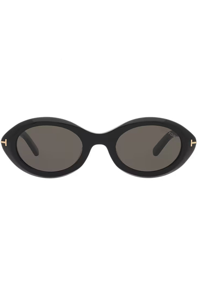 Tom Ford oval sunglasses in gray with black frame and golden T details, shown against a plaid white background.