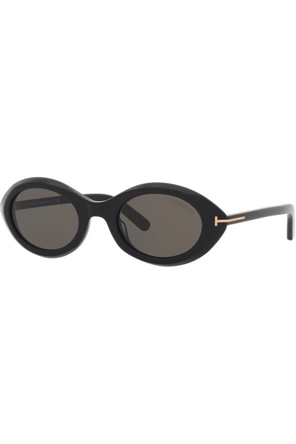 Rotated view of Tom Ford oval sunglasses in gray with black frame and golden T details, shown against a plaid white background.