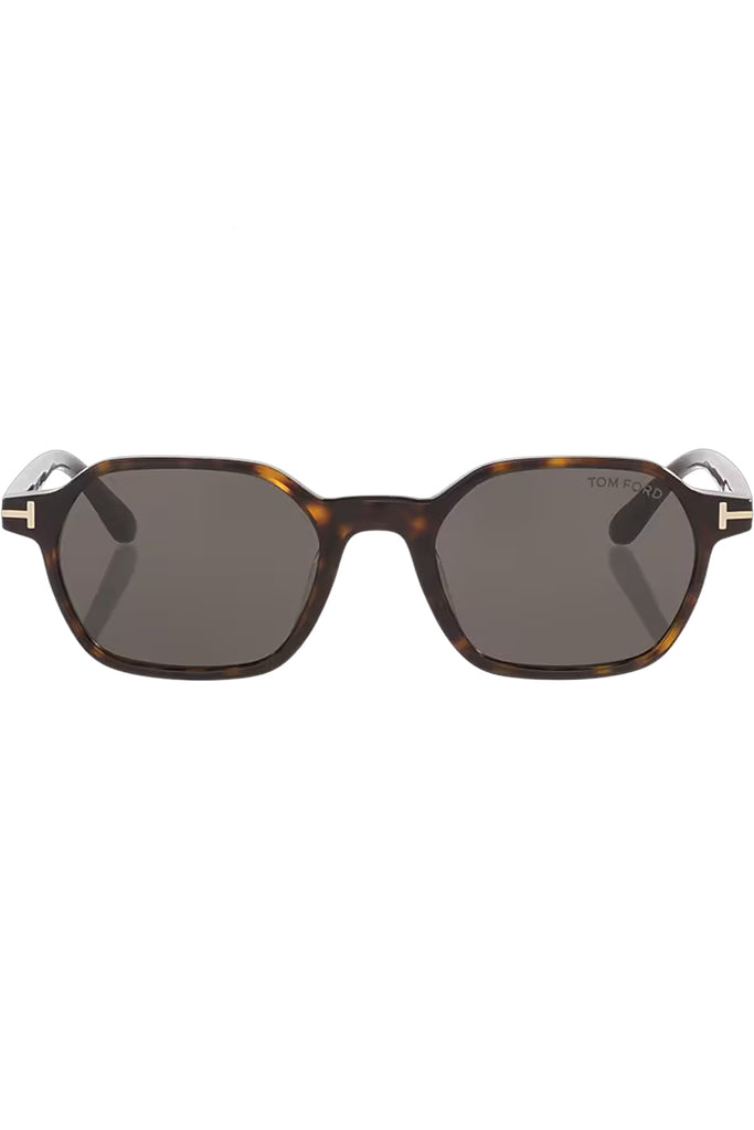 Tom Ford rectangular sunglasses in gray with tortoiseshell frame and golden T details, shown against a plaid white background.