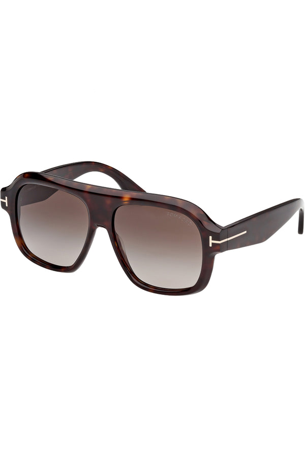Rotated view of Tom Ford mask sunglasses in brown with tortoiseshell frame and metal T details, shown against a plaid white background
