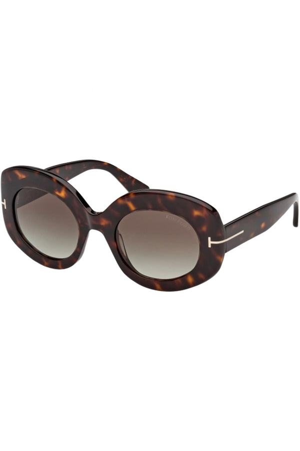 Rotated view of Tom Ford oval sunglasses in brown with dark tortoise frame and metal T details, shown against a plaid white background.
