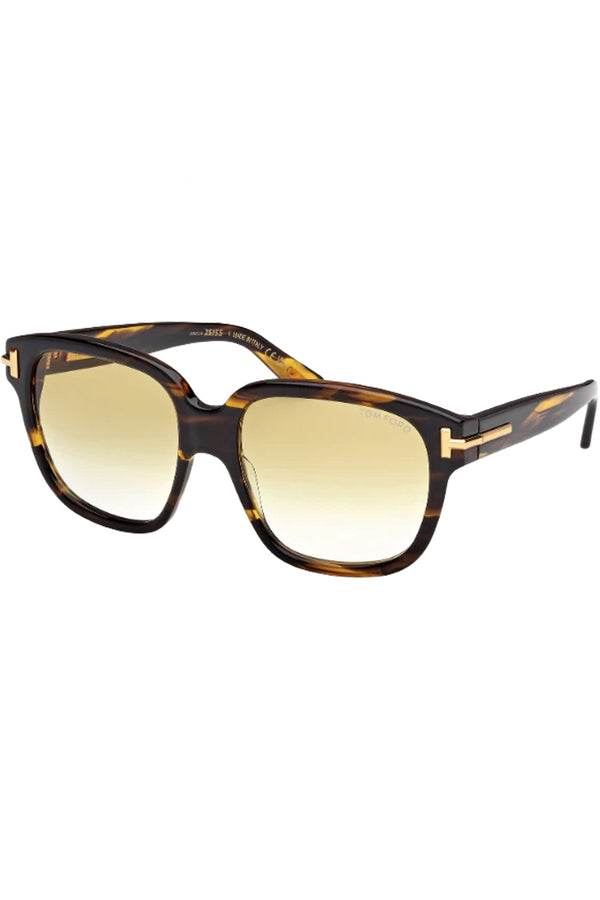 Rotated view of Tom Ford butterfly sunglasses in yellow with tortoise frame and gold T details, shown against a plaid white background.