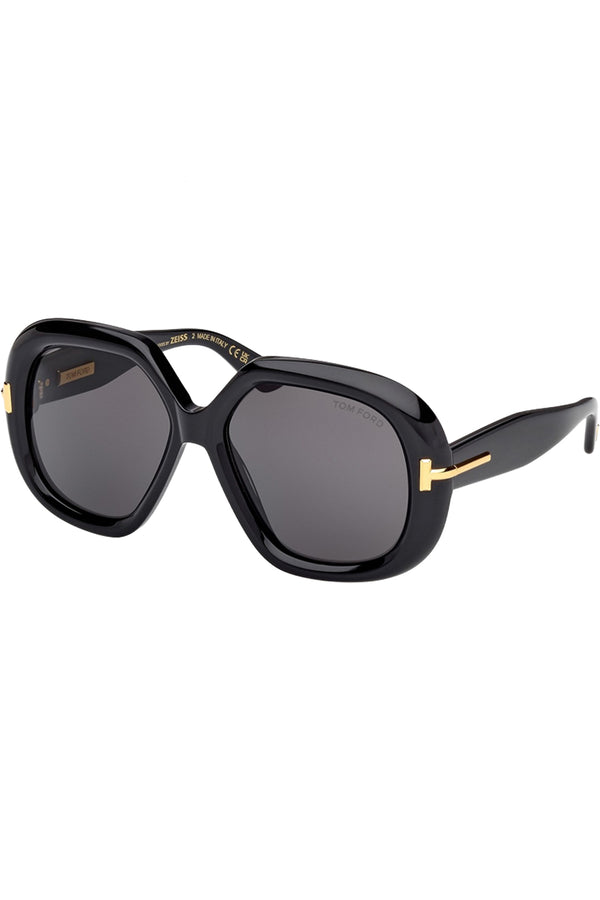 Rotated view of Tom Ford butterfly sunglasses in gray with black frame and gold T details, shown against a plaid white background.