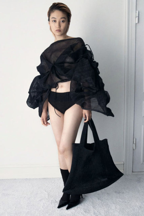 Model wearing the Emma large square-shape totebag in black color from the brand A. ROEGE HOVE