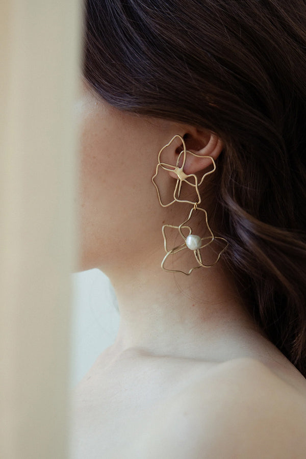 Model wearing the Blooming earrings in gold and pearl colours from the brand ANITA BERISHA