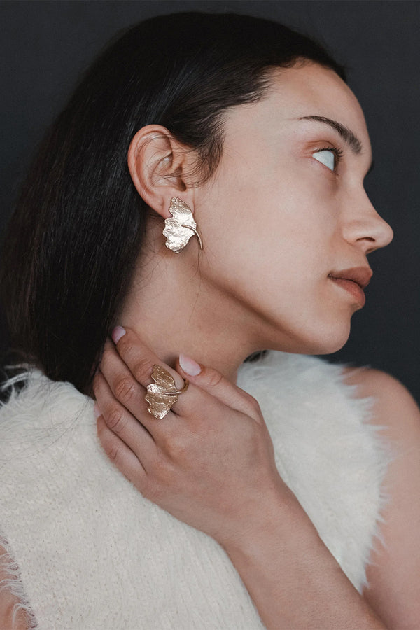 Model wearing the Ginkgo earrings in gold colour from the brand ANITA BERISHA
