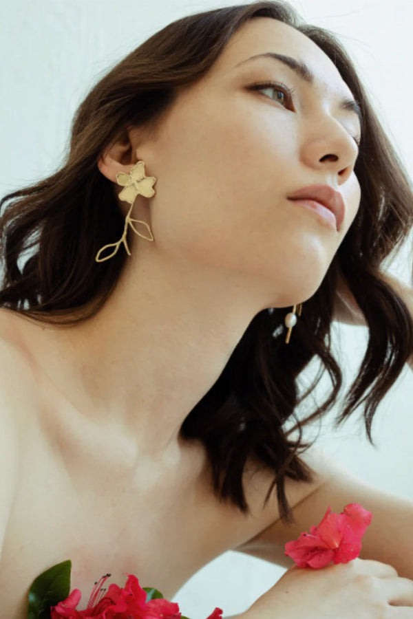 Model wearing the Petals and Branches earrings in gold and pearl colours from ANITA BERISHA