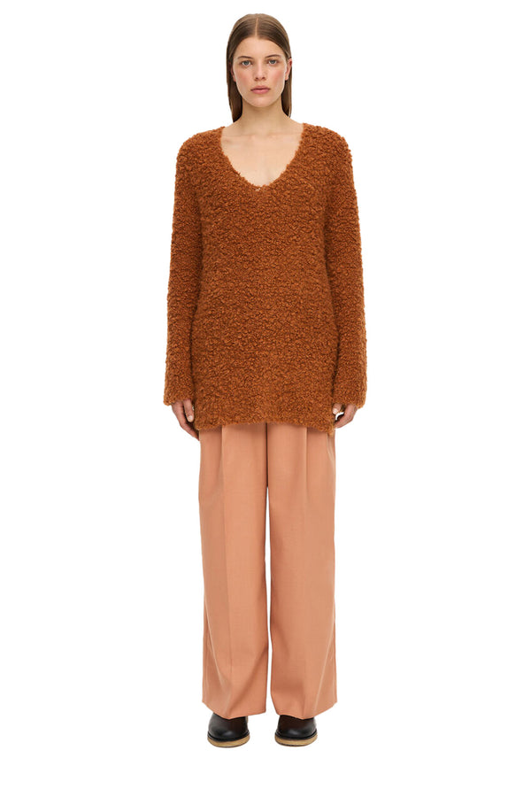 Model wearing the Karlee wide-sleeve Alpaca wool-blend sweaster in brick color from the brand BY MALENE BIRGER