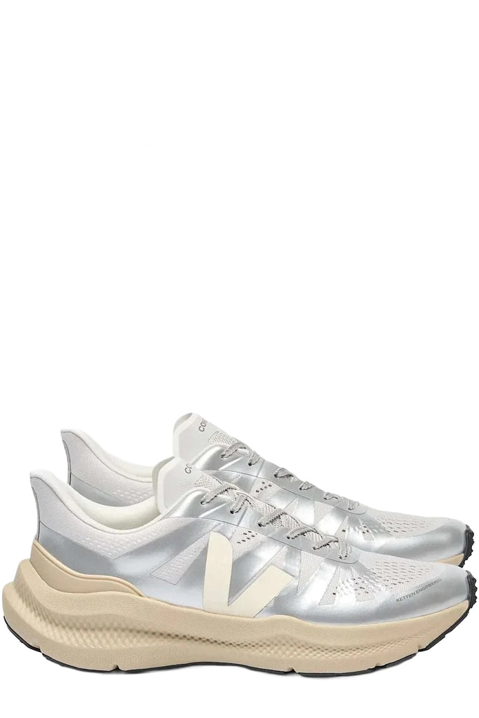 A pair of Veja running shoes in metallic silver and white with beige accents, shown against a plain white background.