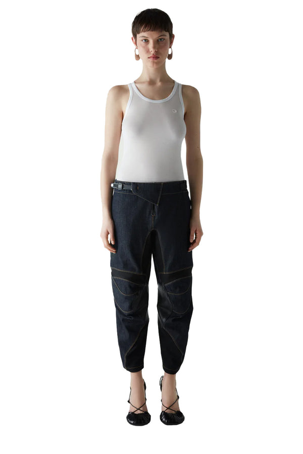 Model wearing the contrast-panel racing denim pants in dark navy color from the brand COPERNI