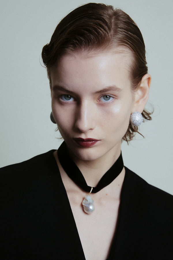 Model wearing the Vivienne necklace in gold and black colour from the brand EMILI