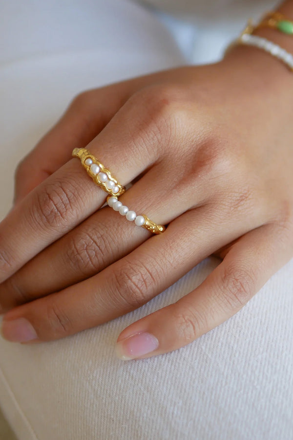 Model wearing the Ailana ring in gold and pearl colour from the brand ENAMEL COPENHAGEN