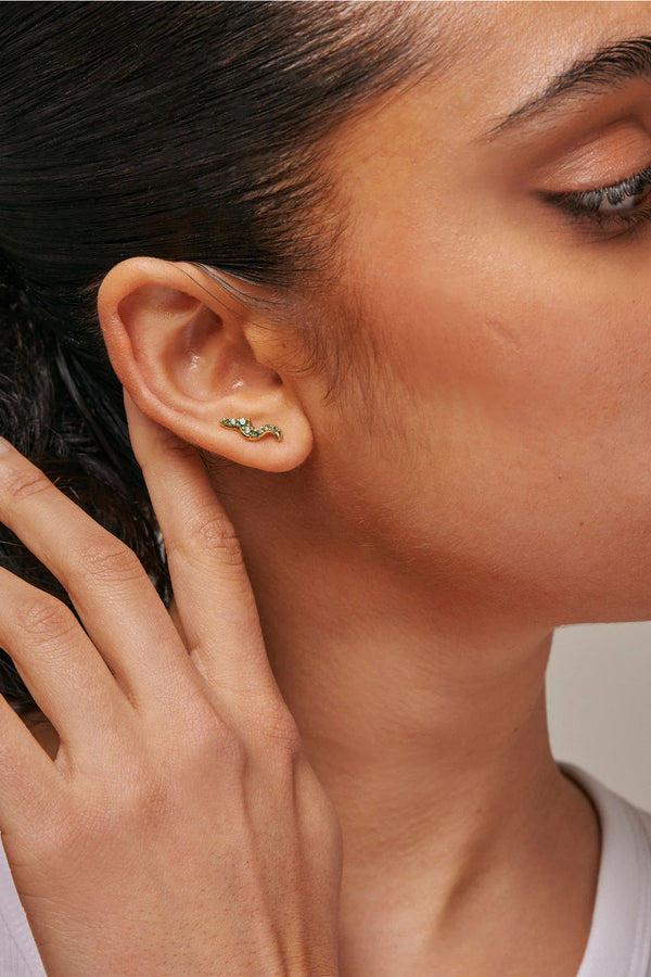 Model wearing the Lydia stud single earring in gold and green colour from the brand ENAMEL COPENHAGEN