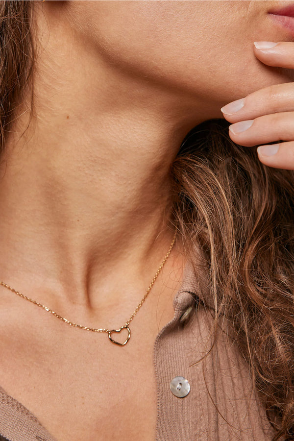 Model wearing The organic heart necklace in gold colour from the brand ENAMEL COPENHAGEN