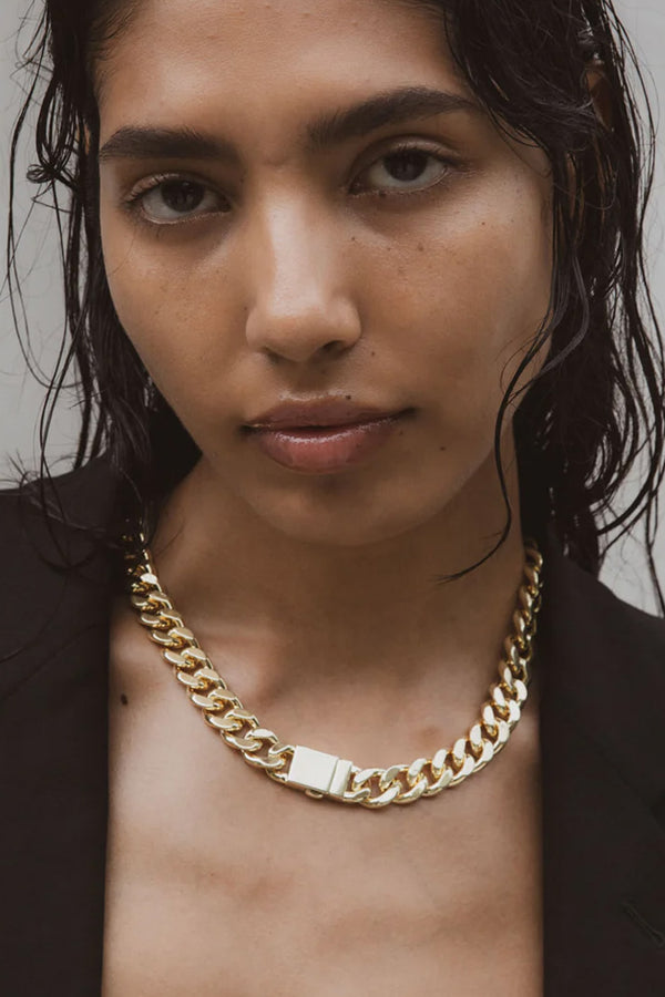 Model wearing the Attitude Statement curb-chain necklace in gold colour from the brand F+H JEWELLERY