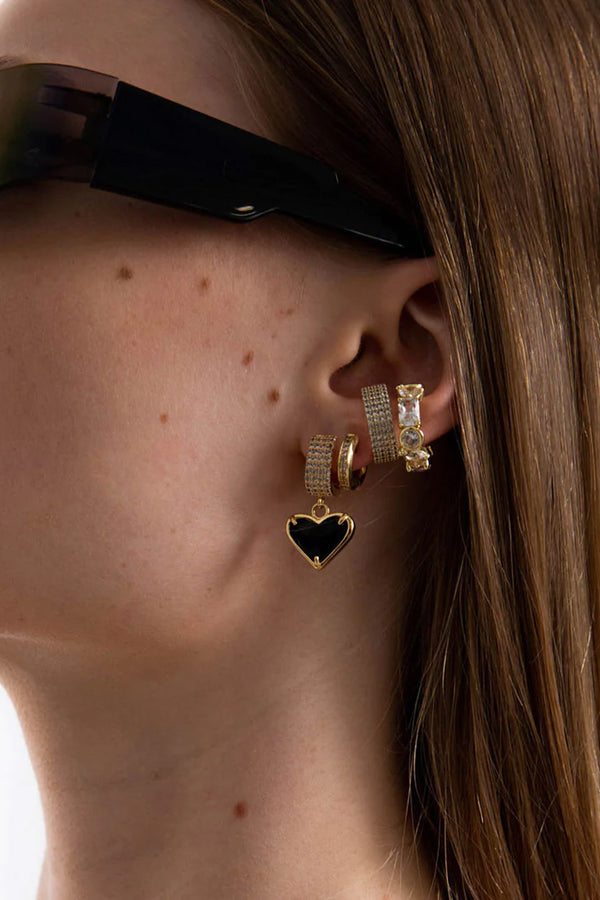 Model wearing the Cindy heart earrings in gold and black colour from the brand F+H JEWELLERY
