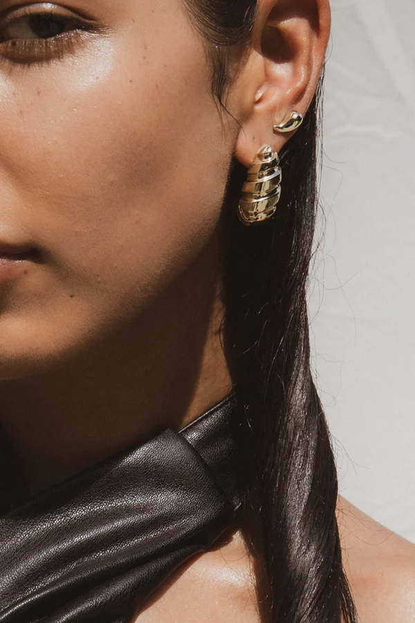 Model wearing the Droplet Statement earrings in gold colour from the brand F+H JEWELLERY