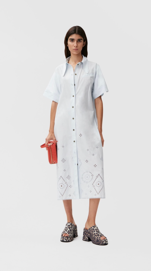 Model wearing the broderie-anglaise midi shirt dress in light blue color from the brand GANNI.