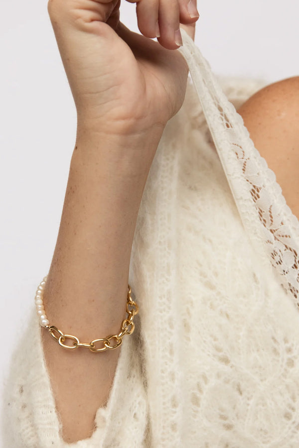 Model wearing the Tokyo link-chain pearl bracelet in gold color from the brand GISEL B.