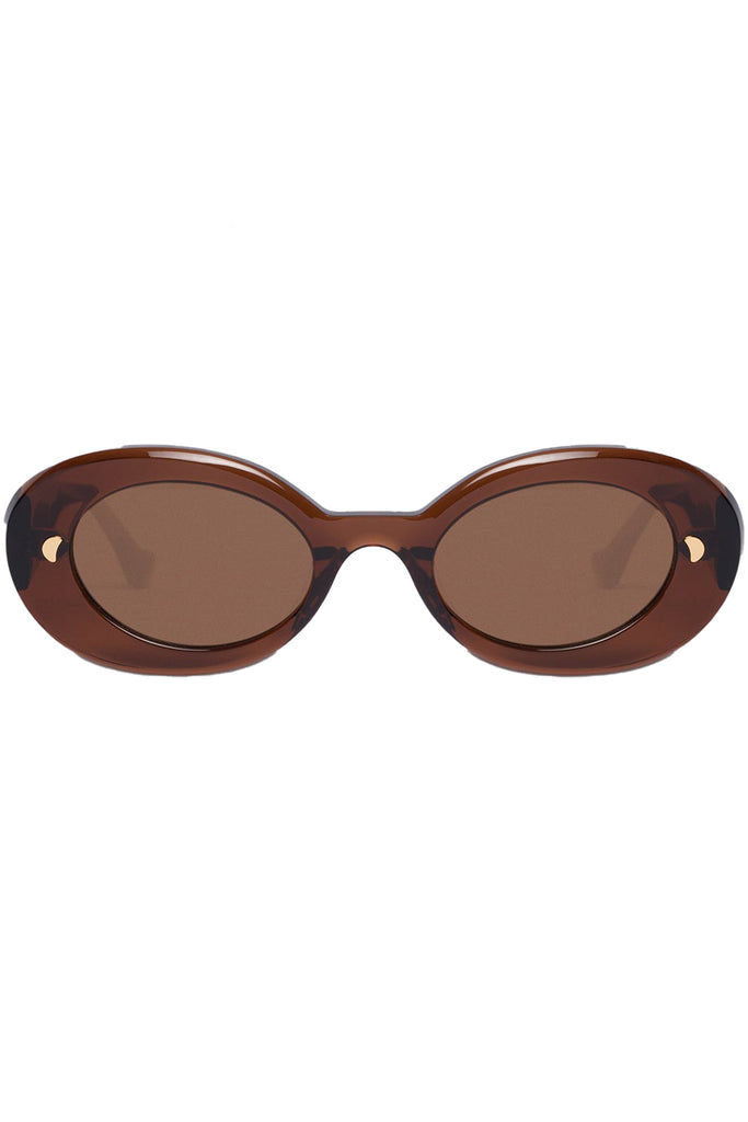 Nanushka oval sunglasses in brown with metal moon signs, shown against a plaid white background.