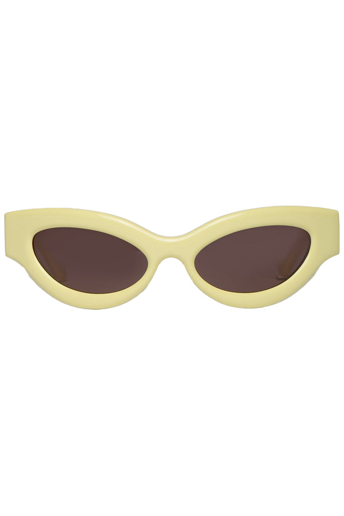 Nanushka oval sunglasses in pale yelllow, shown against a plaid white background.
