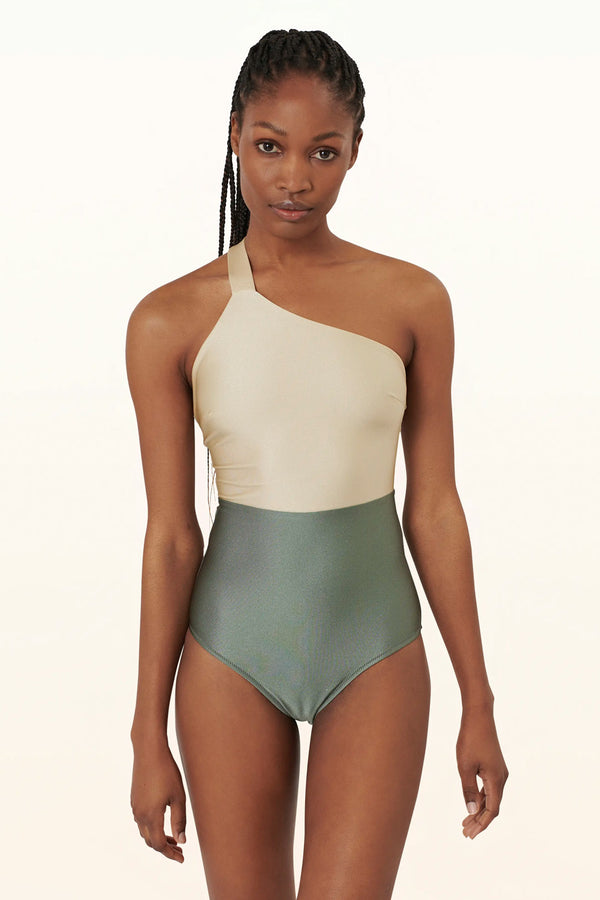 Model wearing the Ypsilon asymmetric contrast-panel swimsuit in green and gold colors from the brand PELSO