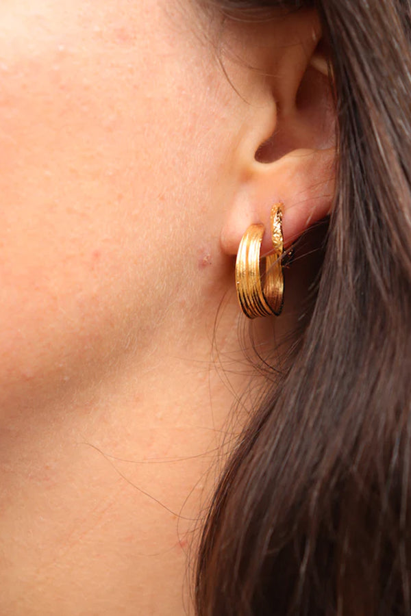 Model wearing the Olive Petit stud earrings in gold colour from the brand PICO COPENHAGEN