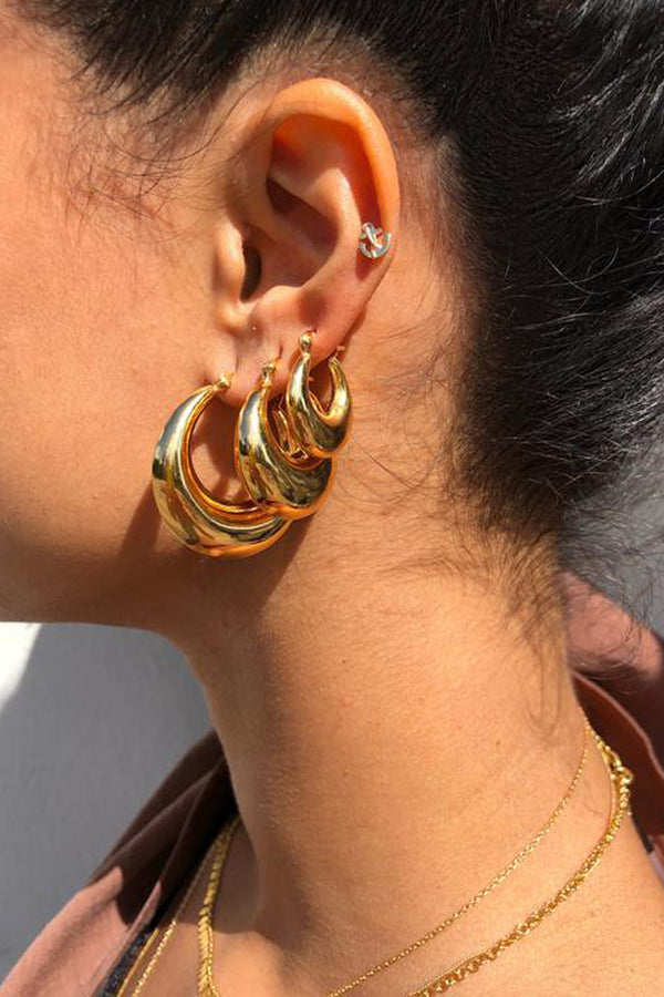 Model wearing the Simi medium hoop earrings in gold colour from the brand PICO COPENHAGEN