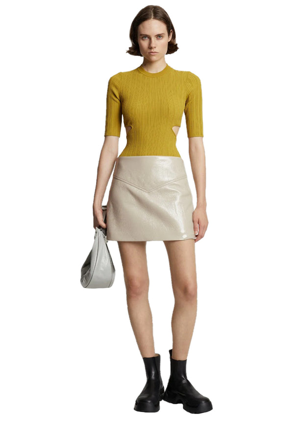 Model wearing the vinyl mini skirt in off white color from the brand PROENZA SCHOULER