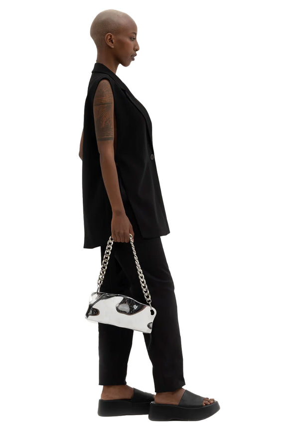 Model wearing the Mayzie chain-handle shoulder bag in silver colour from the brand PUBLISHED BY
