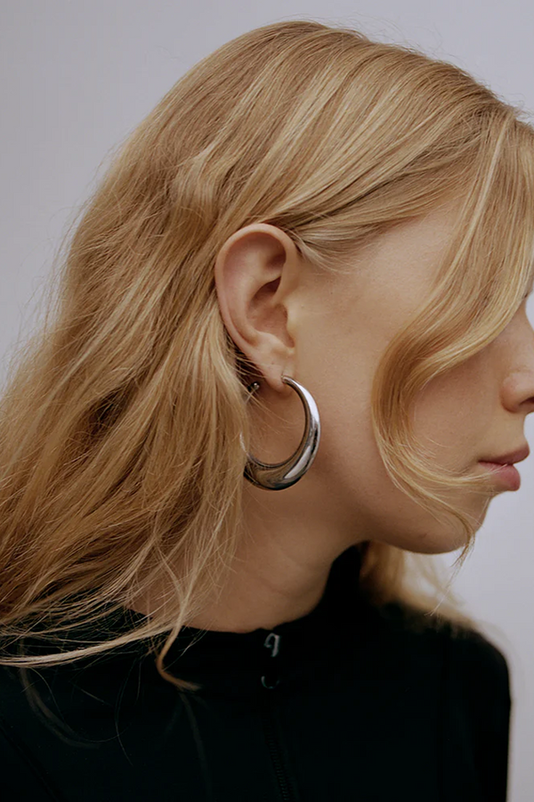 Model wearing the Delta hoop earrings in silver colour from the brand THE GOOD STATEMENT