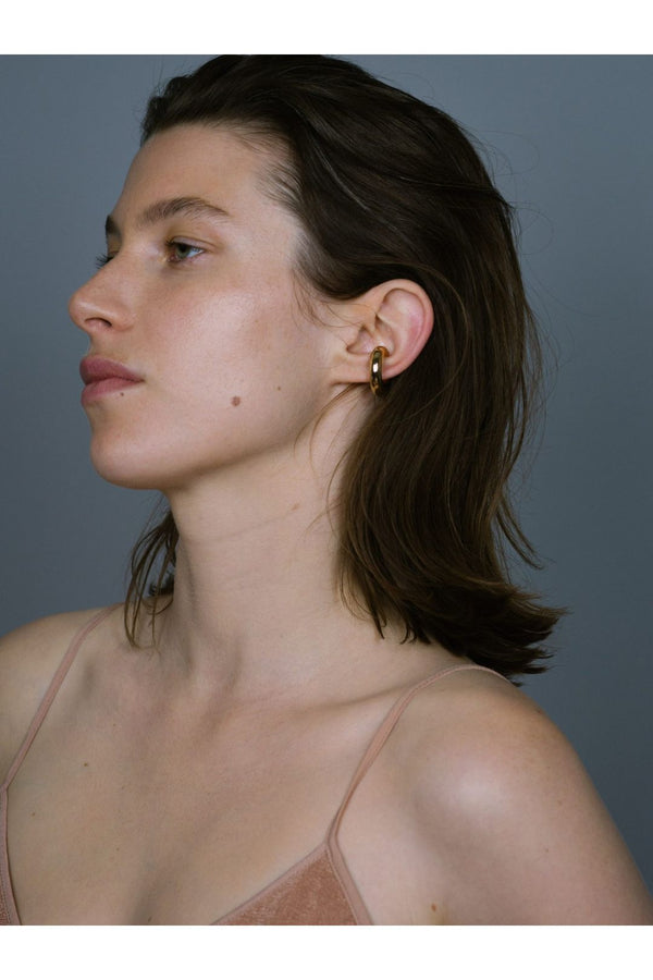 Model wearing the bold earcuff No1 in gold color from the brand SASKIA DIEZ